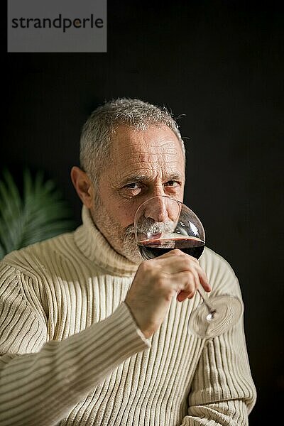 Älterer Mann trinkt Rotwein