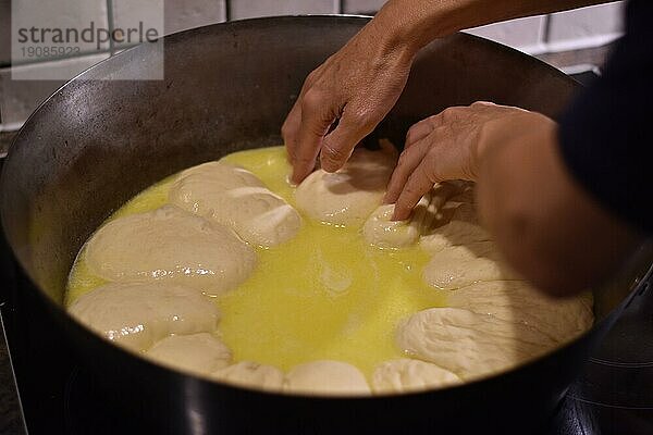 Zubereitung von Dampfnudeln in rustikaler alter Dampfnudelpfanne mit viel Butter  typisch traditionell bayerische Küche  Deutschland  Europa