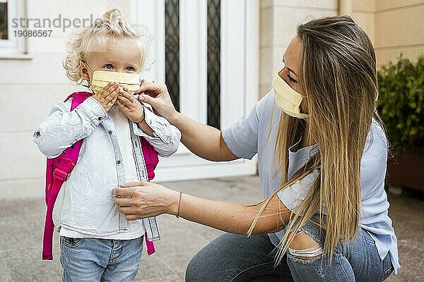 Mutter und Kind mit medizinischen Masken