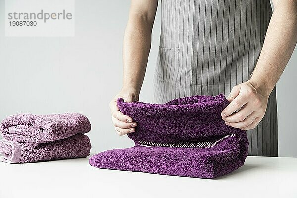 Vorderansicht Person  die Handtücher faltet