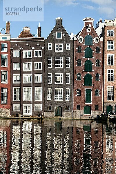 Traditionelle holländische Reihenhäuser an einer Gracht mit Spiegelungen auf dem Wasser in Amsterdam  Holland  Niederlande  Europa