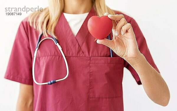 Vorderansicht weiblicher Arzt hält Herzform