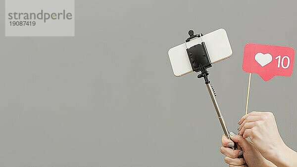 Close up Blogger hält Selfie Stick mit Mobiltelefon