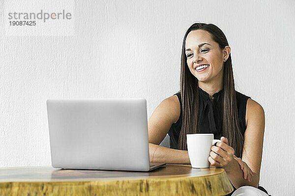 Frau lächelt und überprüft ihren Laptop