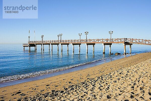 Ruhige Kulisse eines Sandstrandes und eines hölzernen Piers an der Costa del Sol zwischen dem Ferienort Marbella und Puerto Banus in Spanien  Provinz Malaga