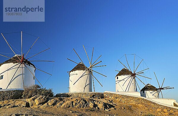 Berühmte Touristenattraktion von Mykonos  Kykladen  Griechenland. Vier traditionelle  weiß getünchte Windmühlen am Hafen von Chora. Sommerabend  blauer Himmel  keine Wolken. Reiseziel  ikonische Aussicht