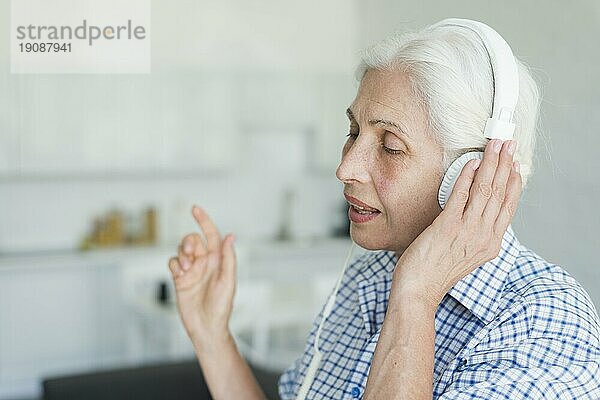 Seitenansicht ältere Frau hört Musik Kopfhörer singen