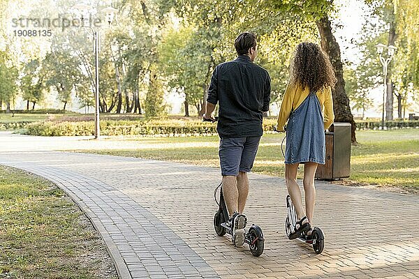 Nettes junges Paar fährt Roller im Freien