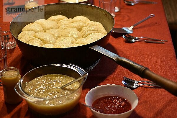 Dampfnudeln in rustikaler alter Dampfnudelpfanne  mit Apfelmus und Johannisbeeren  typisch traditionell bayerische Küche  Deutschland  Europa