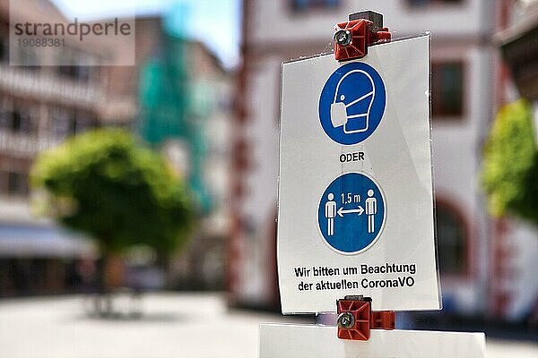 Mosbach  Deutschland  Juni 2021: Schilder für Mundschutz und Abstandsgebot in einer deutschen Stadt mit dem Text Bitte beachten Sie die aktuellen Corona Vorschriften  Europa