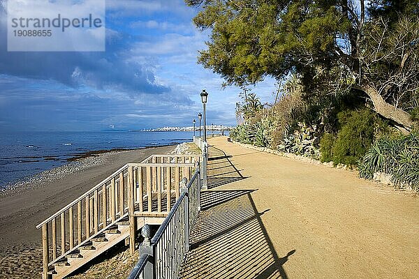 Ruhiger Fußweg mit Treppen zum Strand am Mittelmeer zwischen Marbella und Puerto Banus (am Horizont) in der Region Andalusien  Südspanien