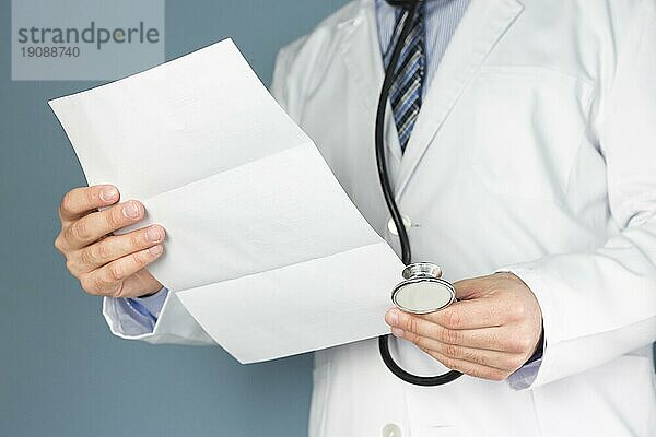 Close up Arzt mit Stethoskop hält medizinischen Bericht Hand