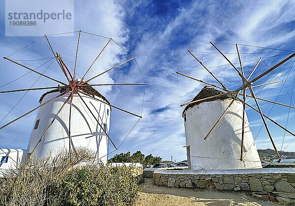 Berühmte Touristenattraktion von Mykonos  Kykladen  Griechenland. Zwei traditionelle weiß getünchten Windmühlen gegen großen Himmel Hintergrund. Sommer  blauer Himmel  schöne Wolken. Reiseziel  ikonische Ansicht. Bild oben