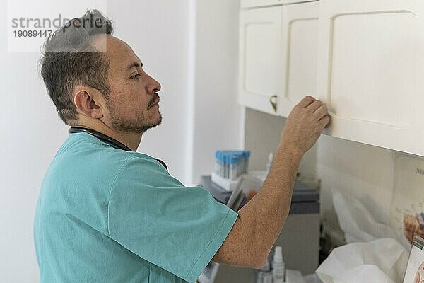 Lateinischer Arzt  der sich in seinem Büro auf die Behandlung vorbereitet