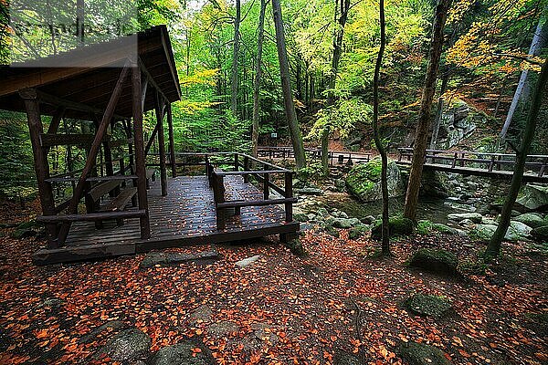 Schutzhütte mit Bänken am Bach im ruhigen Herbstwald des Riesengebirges  Przesieka  Polen  Europa