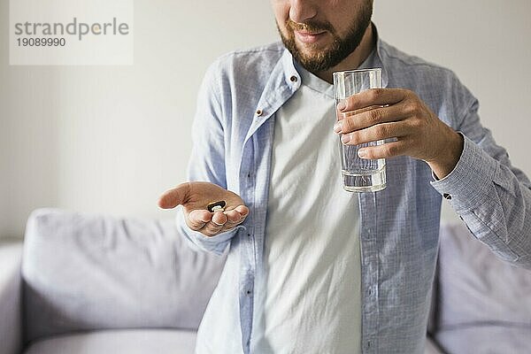 Männliche graue Pillen Glas Wasser