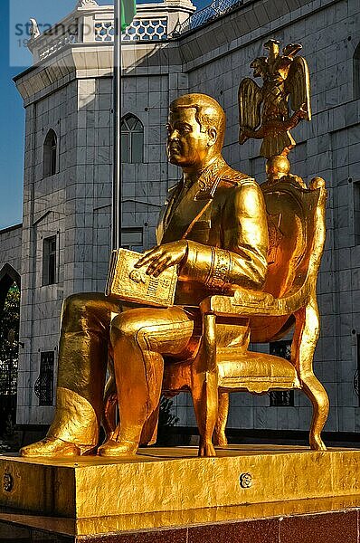 Foto der großen goldenen Statue eines sitzenden Mannes mit Buch in Aschgabat in Turkmenistan