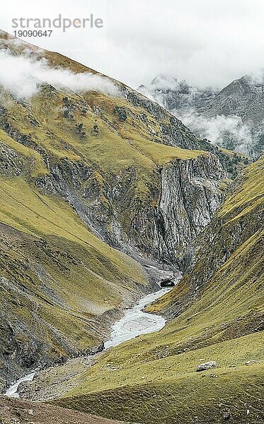 Tiefes Tal mit Bach im Kaschmirgebirge in Indien an einem bewölkten Tag