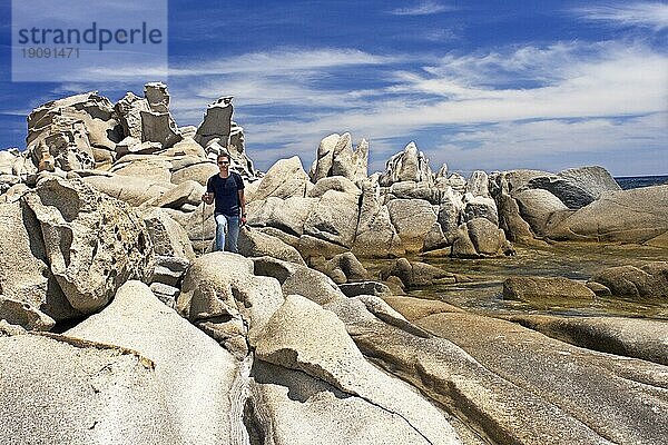 Ein Mann wandert durch Granitformationen an der Punta Molentis auf Sardinien