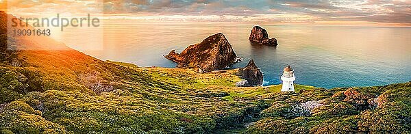 Panorama des Leuchtturms von Cape Brett an der Küste Neuseelands bei Sonnenuntergang. In der Bay of Islands gelegen  die wegen ihrer natürlichen Schönheit ein beliebtes Touristenziel ist