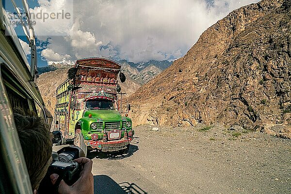 Traditionell geschmückter Lastwagen auf gefährlicher Straße in den Bergen von Pakistan