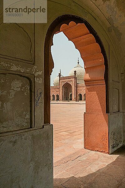 Badshahi Moschee mit Blick durch einen Bogen in einer Arkade in Lahore  Pakistan. Beliebte Touristenattraktion