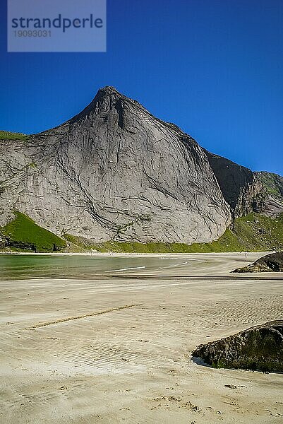 Leerer Strand von Bunes mit Sand und hohen Klippen an einem sonnigen Tag in Norwegen