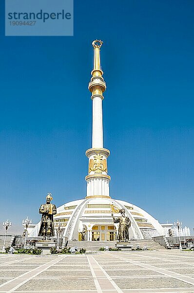 Foto eines großen Denkmals mit großen goldenen Statuen von Männern auf einem Platz in Aschgabat in Turkmenistan