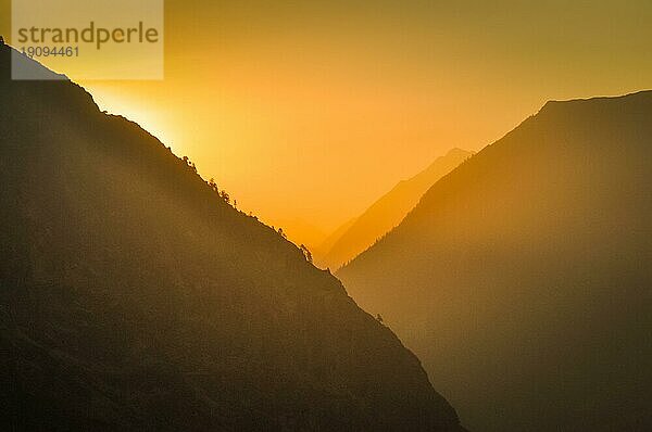 Foto des Sonnenlichts hinter den Bergen bei Sonnenaufgang in Dolpo in Nepal