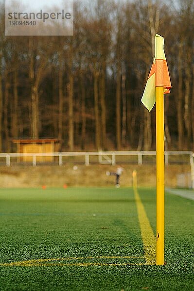 Eckpfosten eines Fußballfeldes aus Kunstrasen mit Fußballspieler