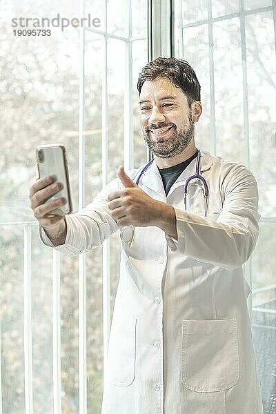 Latino Arzt bei Videokonferenz mit seinem Telefon