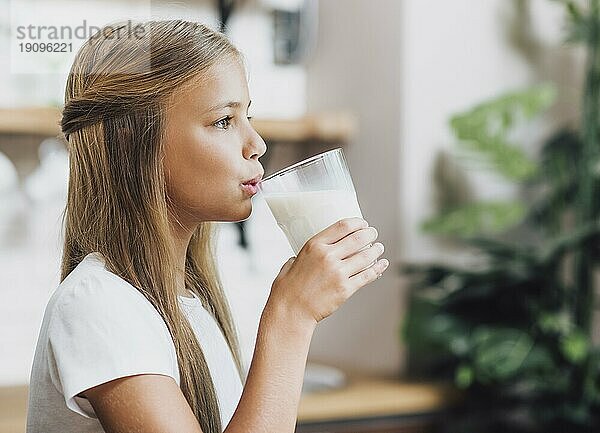 Seitenansicht Mädchen trinkt Glas Milch