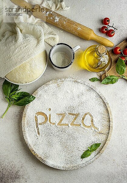 Draufsicht Pizzateig mit Tomaten Wort geschrieben Mehl