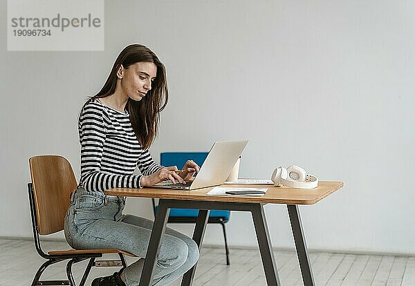 Junge Geschäftsfrau arbeitet am Laptop