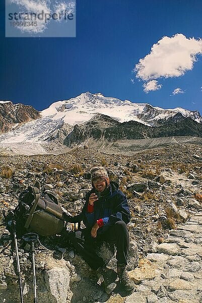 Junger lächelnder Wanderer bei einer Rast auf dem Weg zum Huayna Potosi  einem Gipfel in den bolivianischen Anden