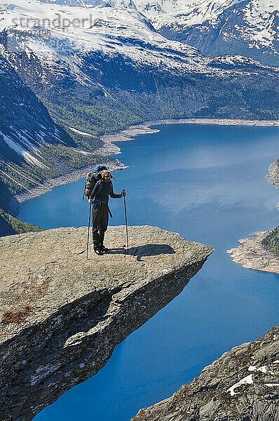 Wanderer macht eine Pause auf dem Gipfel des Trolltunga Felsens in Norwegen