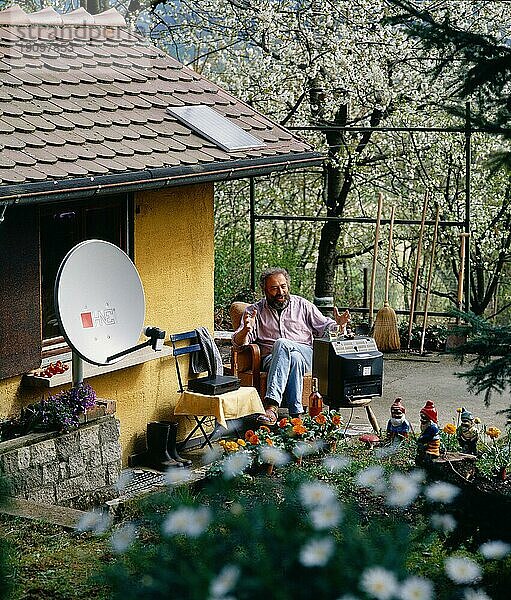 Schrebergaertner beim Fernsehen im Garten mit Satelittenschuessel digital und 6x6 Dia