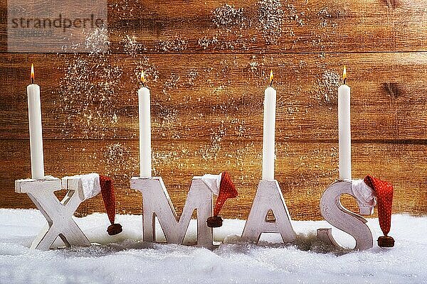 Vier brennende Kerzen auf den Buchstaben XMAS