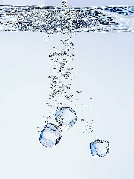 Eiswürfel  die in klares Wasser fallen  mit Blasen