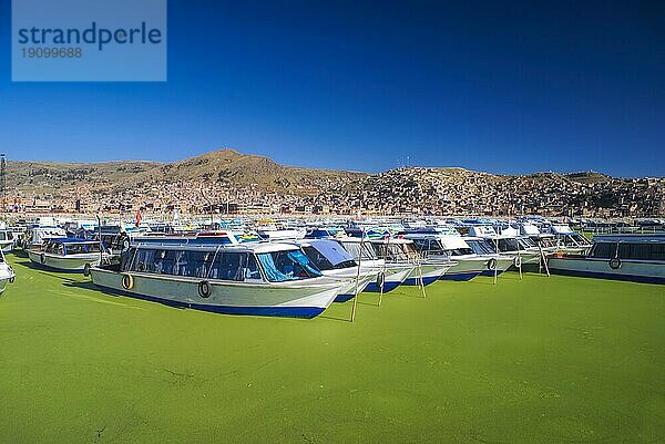 Boote auf grünem Wasser im Hafen von Islas Flotantes de los Uros in Peru  Südamerika