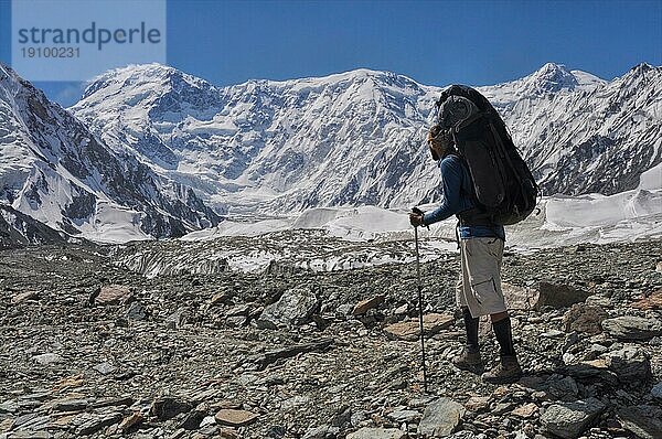 Abenteuerlustiger Wanderer mit Rucksack auf dem Engilchek Gletscher im malerischen Tian Shan Gebirge in Kirgisistan