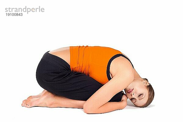 Junge Frau macht entspannende Yogaübung genannt Embryo Pose  Sanskrit Name: Pindasana  isoliert über weißem Hintergrund