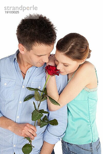 Junges attraktives Paar in romantischer Stimmung teilen einen zärtlichen Moment vor weißem Hintergrund