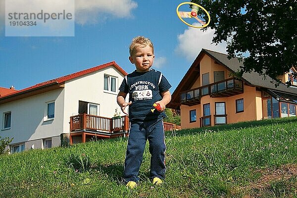 Kleiner Junge spielt mit Propeller-Spielzeug  Sommer