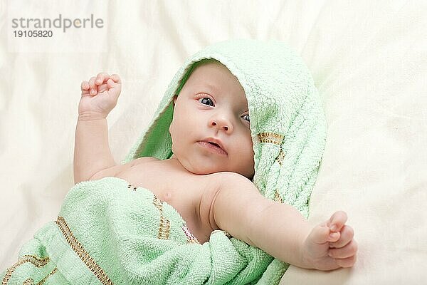 Zehn Wochen alt niedlichen kleinen Baby Mädchen Kleinkind in Handtuch gewickelt streckte ihre Arme