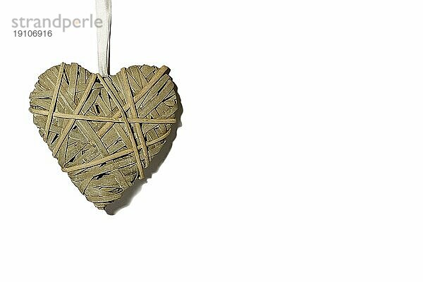 Geflochtenes Herz vor einem weißen Hintergrund  Thema Liebe und Valentinstag. Platz zum Kopieren. Ein graues Herz