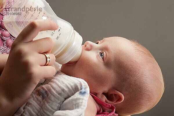Kleines Mädchen trinkt Milch aus der Flasche
