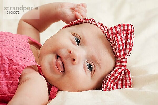 Porträt eines fröhlichen eleganten Baby Mädchen Kleinkind trägt rosa Schleife