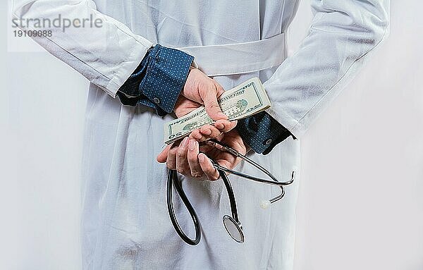 Unehrlicher Arzt versteckt Geld. Medizinische Korruption und Bestechung Konzept  Korrupter Arzt versteckt Geld zurück