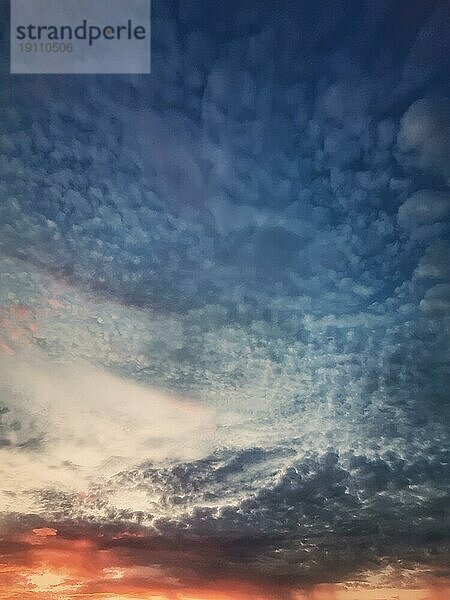 Dreamlike Sonnenuntergang Himmel vertikalen Hintergrund mit flauschigen und bunten Zirruswolken über dem Horizont. Sonnenaufgang himmlischen Blick